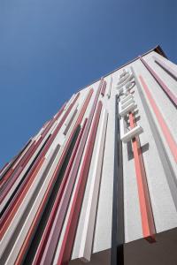 un grand bâtiment avec des bandes rouges et blanches sur lui dans l'établissement Stadthotel Kachelofen, à Krumbach