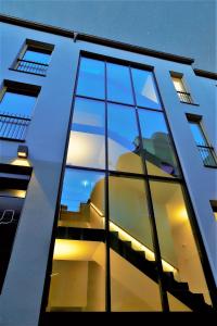 un bâtiment dont les fenêtres reflètent le ciel dans l'établissement Stadthotel Kachelofen, à Krumbach