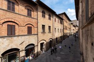 Un gruppo di persone che camminano per strada in un vicolo di Residenza D'Epoca Palazzo Buonaccorsi a San Gimignano