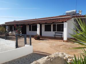 a white house with a bench in front of it at Quinta Cosy in Paderne