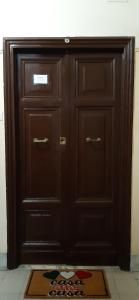 duże drewniane drzwi z matą przed nimi w obiekcie andri.trastevere w Rzymie