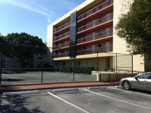 een parkeerplaats met een tennisbaan voor een gebouw bij Surfsider Resort - A Timeshare Resort in Pompano Beach