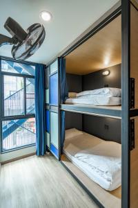 two bunk beds in a room with a window at 19A BANGKOK HOSTEL in Bangkok