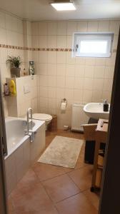 een badkamer met een bad, een toilet en een wastafel bij Ferienwohnung -Zur Sonnenleite- in Dörfles