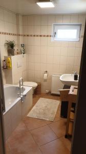 a bathroom with a tub and a toilet and a sink at Ferienwohnung -Zur Sonnenleite- in Dörfles-Esbach