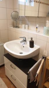 a bathroom with a white sink and a mirror at Ferienwohnung -Zur Sonnenleite- in Dörfles-Esbach +6 photos