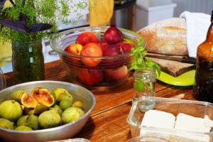 a table with a bowl of apples and a bowl of cheese at Himara Hostel in Himare