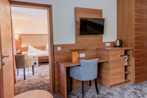 巴特戈伊瑟恩的住宿－烏爾福赫格伊斯爾姆勒酒店，酒店客房配有书桌和电视。
