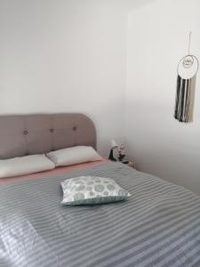 a bed with a pillow sitting on top of it at Sable Blanc Apartments in Ixia