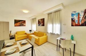 een woonkamer met een gele bank en een tafel bij Casabetta "Felsina" in Bologna