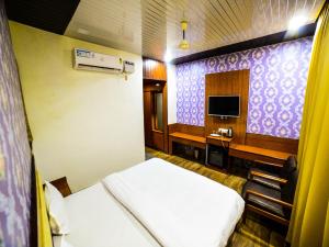 een kamer met 2 bedden, een bureau en een televisie bij The Royal Paradise Resort and Salt Yard in Bīr