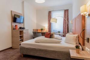 Cette chambre comprend un grand lit et un bureau. dans l'établissement Wohlfühlhotel Goiserer Mühle, à Bad Goisern