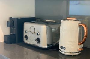 a toaster and a toaster oven sitting on a counter at Beautiful Home close to Shopping Mall and Train Hornsby in Hornsby