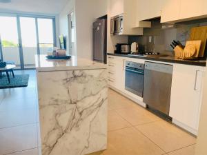 a kitchen with marble counter tops and appliances at Beautiful Home close to Shopping Mall and Train Hornsby in Hornsby