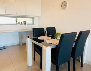 a dining room with a table and black chairs at Beautiful Home close to Shopping Mall and Train Hornsby in Hornsby