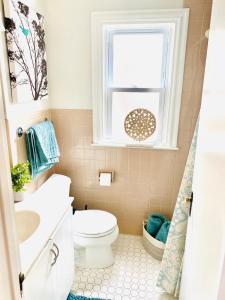 a bathroom with a toilet and a window at Mi casa su casa in Cheektowaga