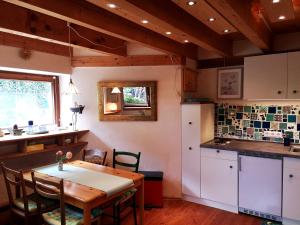 une cuisine avec une table en bois, une table et des chaises dans l'établissement SEENAH - Ihre Wohnung am Bodensee / Untersee, à Gaienhofen