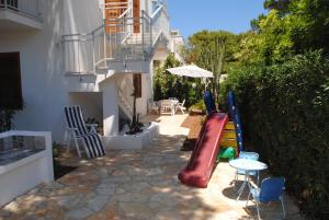 a backyard with a slide and a table and chairs at Villa Smeralda in San Vito lo Capo