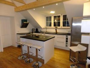 cocina con armarios blancos y encimera negra en LakeStarnberg Apartments, en Pöcking