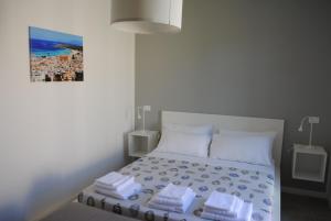 a white bedroom with a bed with towels on it at Villa Smeralda in San Vito lo Capo