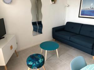 a living room with a blue couch and a table at LES CEDRES, Résidence LES OCEANES in Pornichet +22 photos