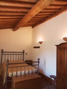 Agriturismo Selvella في Allerona: غرفة نوم بسرير وسقف خشبي