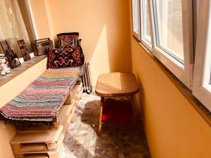 a room with a bench and a stool and a window at Апартамент Панорама Трявна - кът за отдих, въздухолечение и почивка in Tryavna