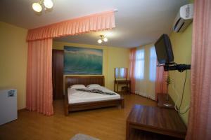 a bedroom with a bed and a television in it at Kamchatka Guest House in Anapa