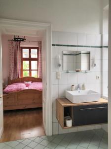 a bathroom with a sink and a bed with a window at Ferienappartment zum grünen Hirsch in Bad Ischl