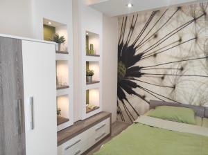 um quarto com uma cama verde e uma parede com prateleiras em RP FitLife Stúdió és Vendégház em Szentgál