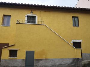 un edificio amarillo con una escalera en el lateral en Guest house le grazie, en Orte