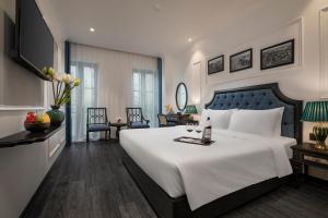 Schlafzimmer mit einem großen weißen Bett mit blauem Kopfteil in der Unterkunft Ha Long Essence Hotel in Hạ Long