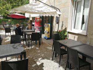 un restaurante con mesas, sillas y sombrilla en La Locanda di Bivigliano en Bivigliano