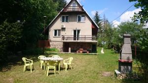 a table and chairs in front of a house at Dom Nad Jeziorem Staw in Gawrych Ruda