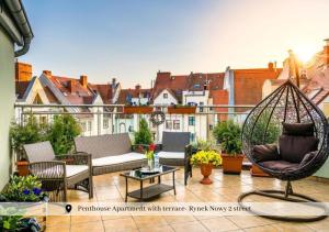 een patio met stoelen en een schommel op een balkon bij 5-stars Apartments - Old Town in Szczecin