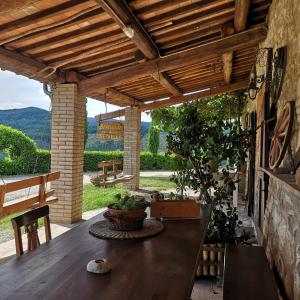 a patio with a wooden table and a wooden ceiling at Agriturismo Selvella in Allerona