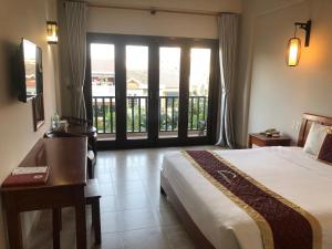Postel nebo postele na pokoji v ubytování Sunshine Hoian Hotel