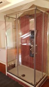 a glass shower in a room with red tile at Estes in Crotone