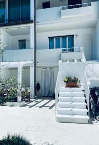 una scala bianca di fronte a un edificio di casa Cervia by studio Ebi a Cervia
