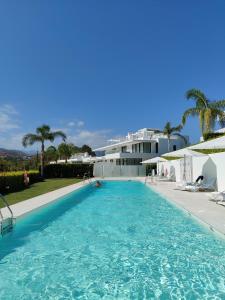 a large swimming pool in front of a house at Marbella GOLF & SEA LODGE in Estepona