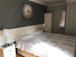 um quarto com uma cama branca e uma flor branca na parede em Grove Lodge B&B em Monaghan