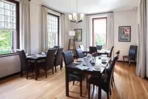 a dining room with tables and chairs and windows at Elgin Vintners Country House in Elgin