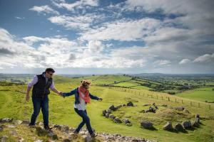 a man and woman standing on top of a hill at Loughcrew Glamping in Oldcastle