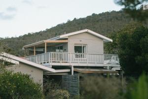 a white house with a porch and a balcony at Leisure Isle Loft Apartment in Knysna