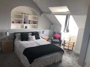 a bedroom with a bed with a black and white comforter at Carlton Guest House in Stratford-upon-Avon