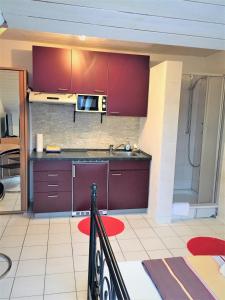 a kitchen with red cabinets and a sink at Studentenwohnung in Allensbach