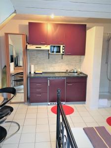 a kitchen with red cabinets and a sink at Studentenwohnung in Allensbach