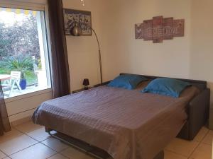 un lit dans une chambre avec une grande fenêtre dans l'établissement Fréjus centre, à Fréjus