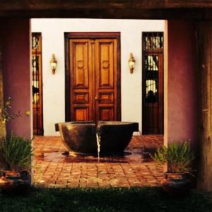 a fountain in front of a house with a door at La Negrita Casa de Campo in Azcuénaga