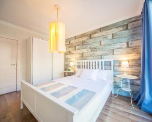 a bedroom with a white bed and a wooden wall at Villa Ina & Eva Bayview Deluxe in Burgas City +28 photos